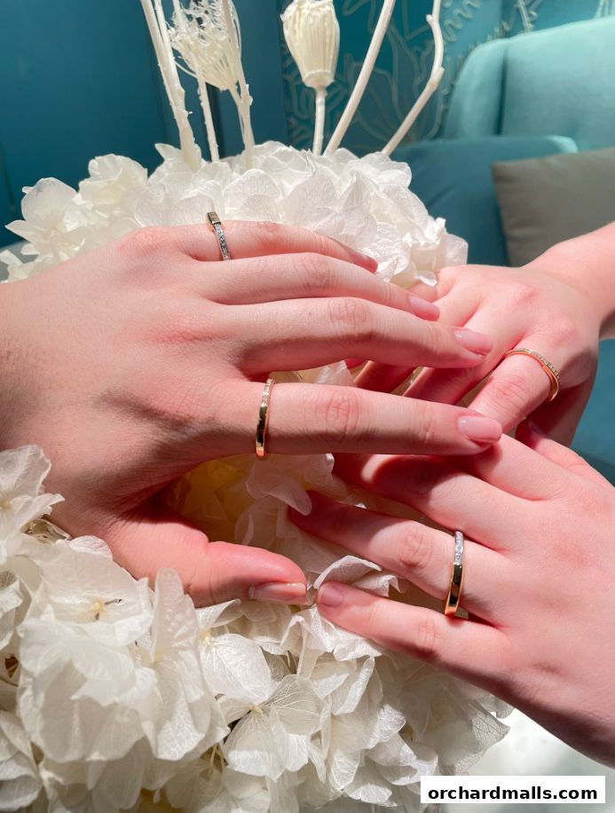Hands adorned with Tiffany & Co. rings, surrounded by delicate white flowers.
