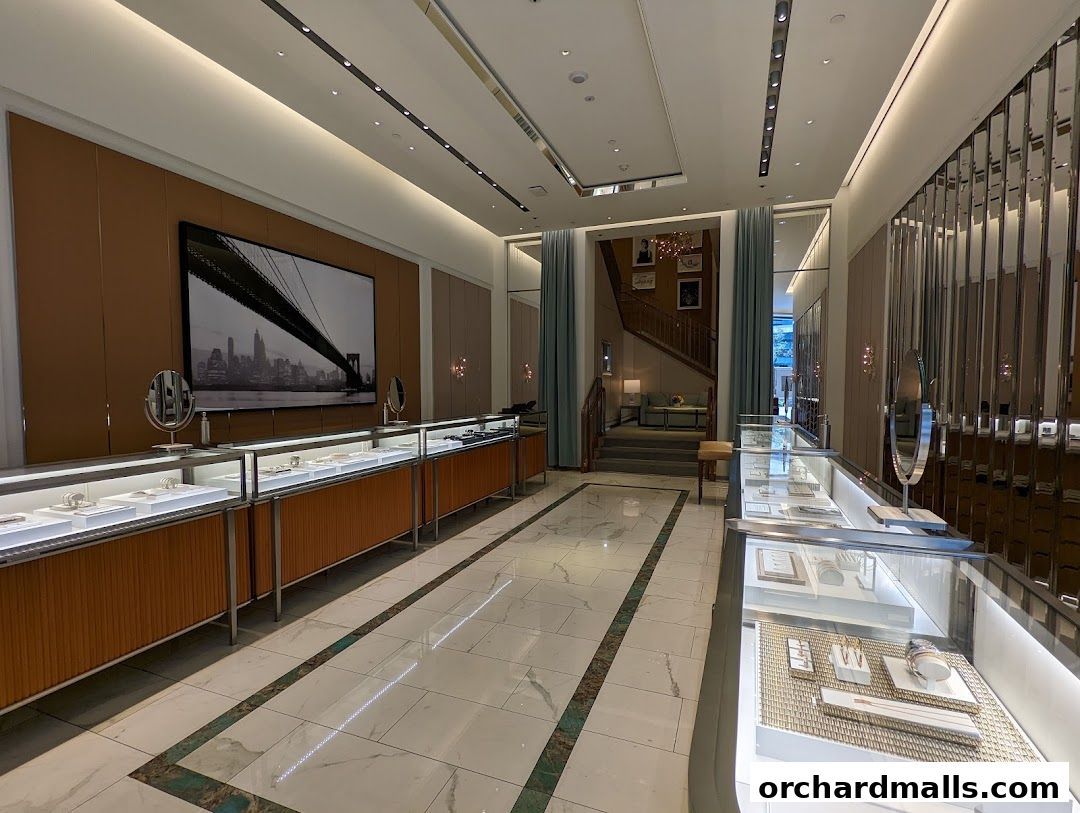 Interior view of a luxurious Tiffany & Co. jewelry store with display cases and a grand staircase.
