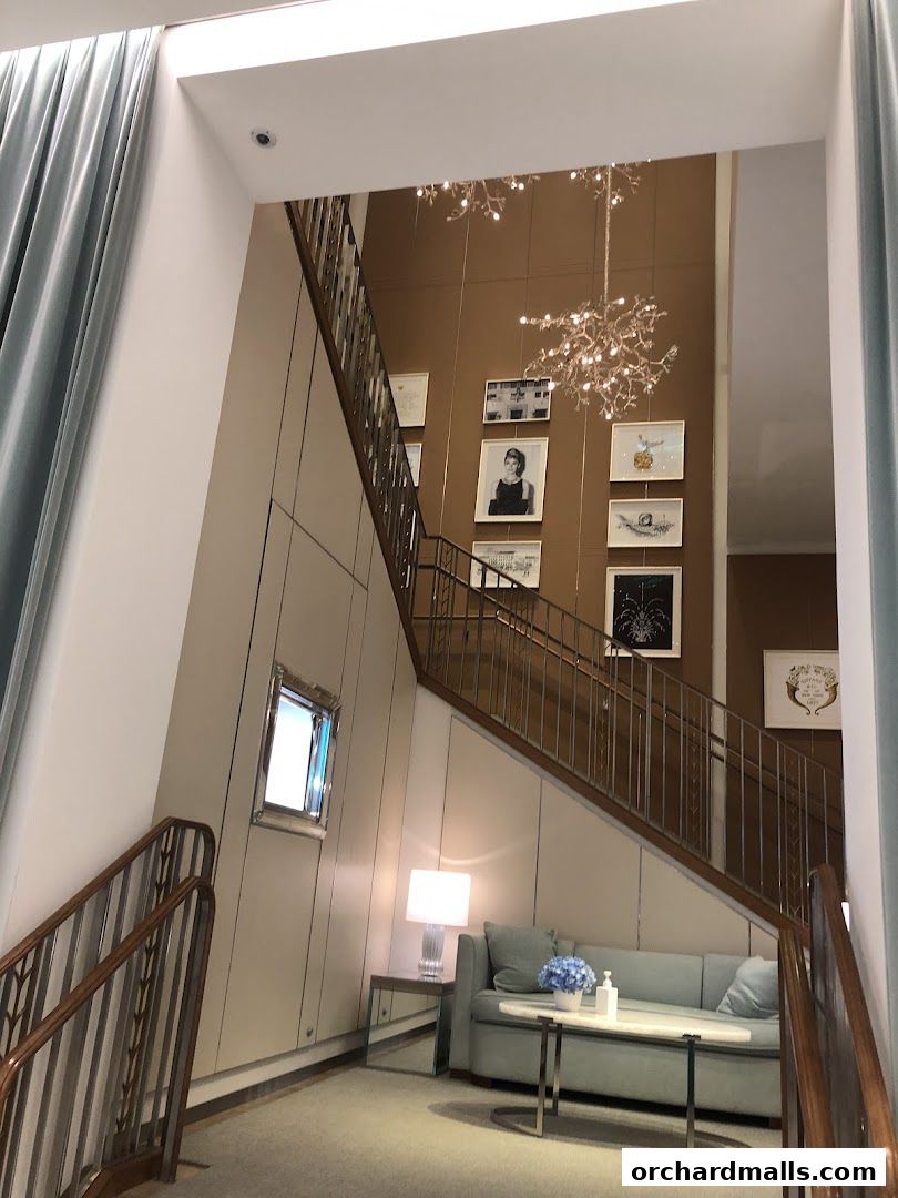 Interior shot of Tiffany & Co. featuring a staircase, seating area, and decorative wall art.