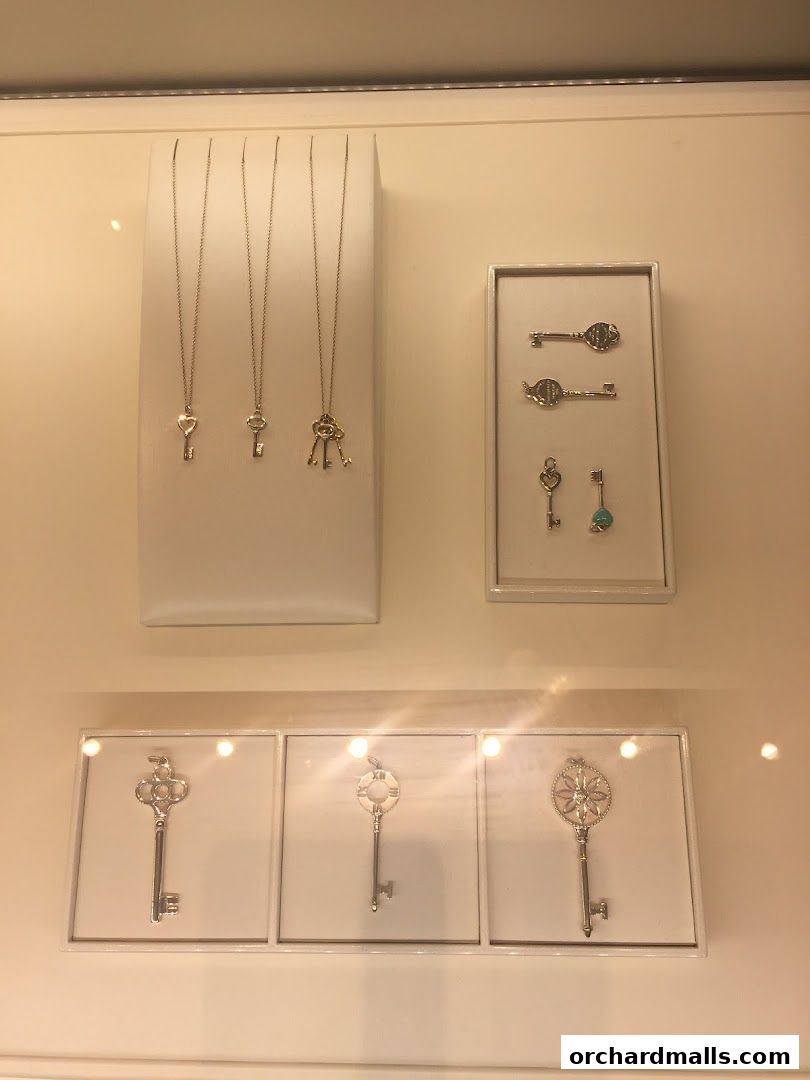 Tiffany & Co. display featuring various key-shaped necklaces and pendants.