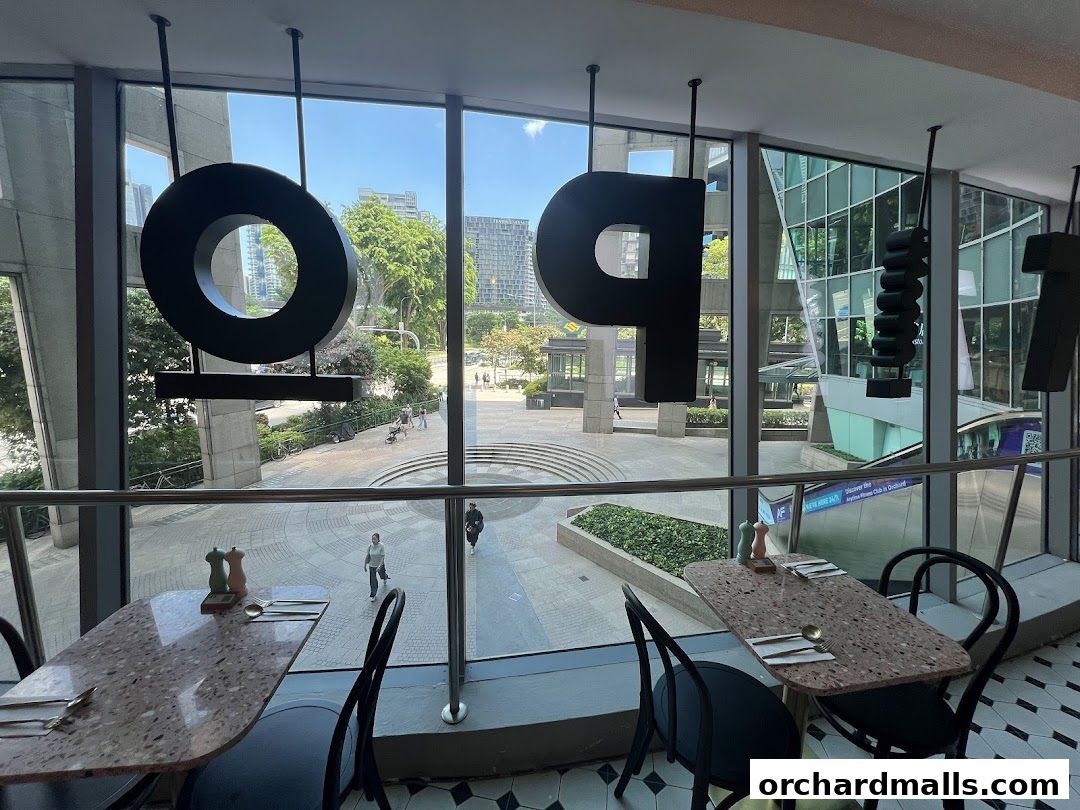 Interior view of Tipo Strada Wheelock with large decorative letters and tables overlooking an outdoor plaza.
