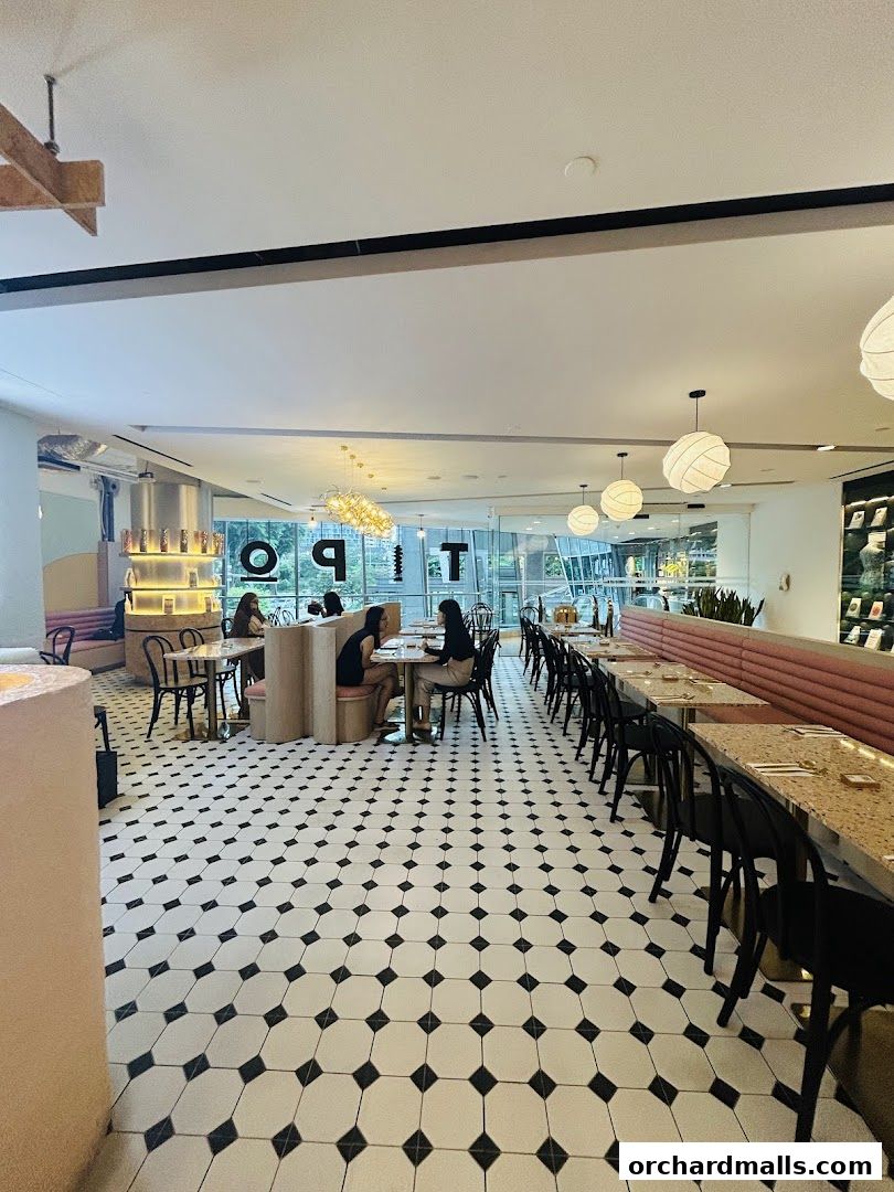 Interior view of a modern cafe with black and white tiled floor and pink seating.