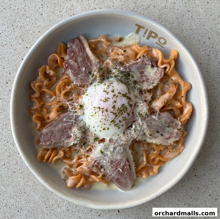 A close-up shot of a delicious pasta dish topped with a poached egg and meat.