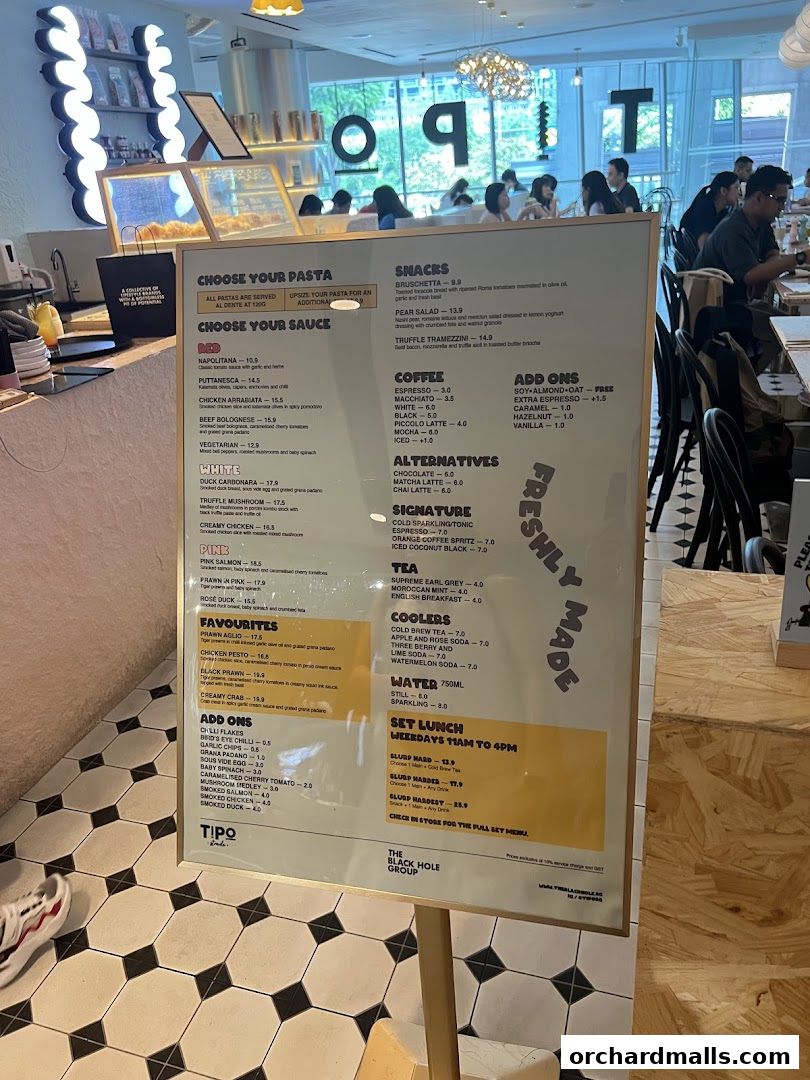 A menu board displaying pasta choices, sauces, snacks, coffee, tea, coolers, and set lunch options.