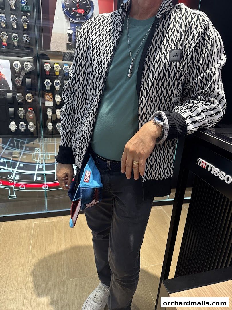 A person stands in front of a Tissot watch display, showcasing various timepieces.
