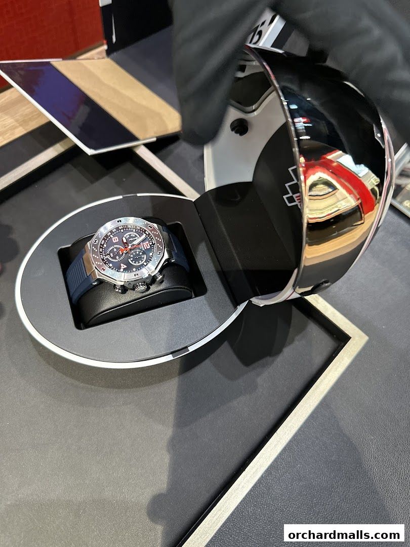 A Tissot watch is displayed in its packaging, with a gloved hand opening the lid.