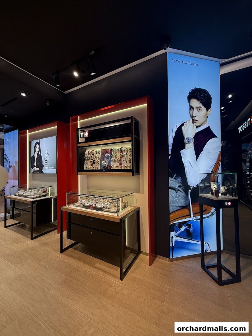 Interior of a Tissot watch store showcasing display cases with watches and a large advertisement.