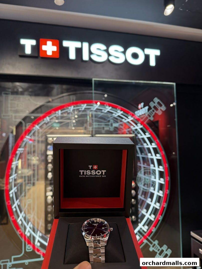 A Tissot watch displayed in its branded box with the store's logo visible.
