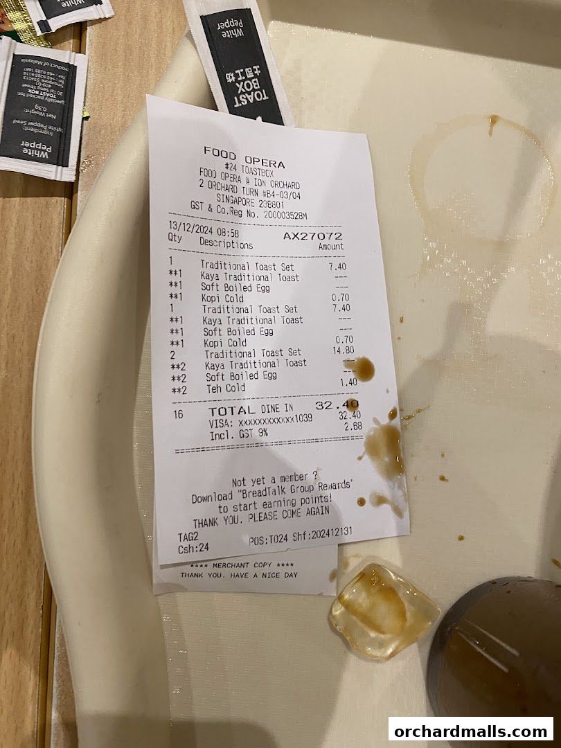 A receipt from Toast Box ION Orchard showing a purchase of traditional toast sets, kaya toast, soft boiled eggs, kopi, and teh.