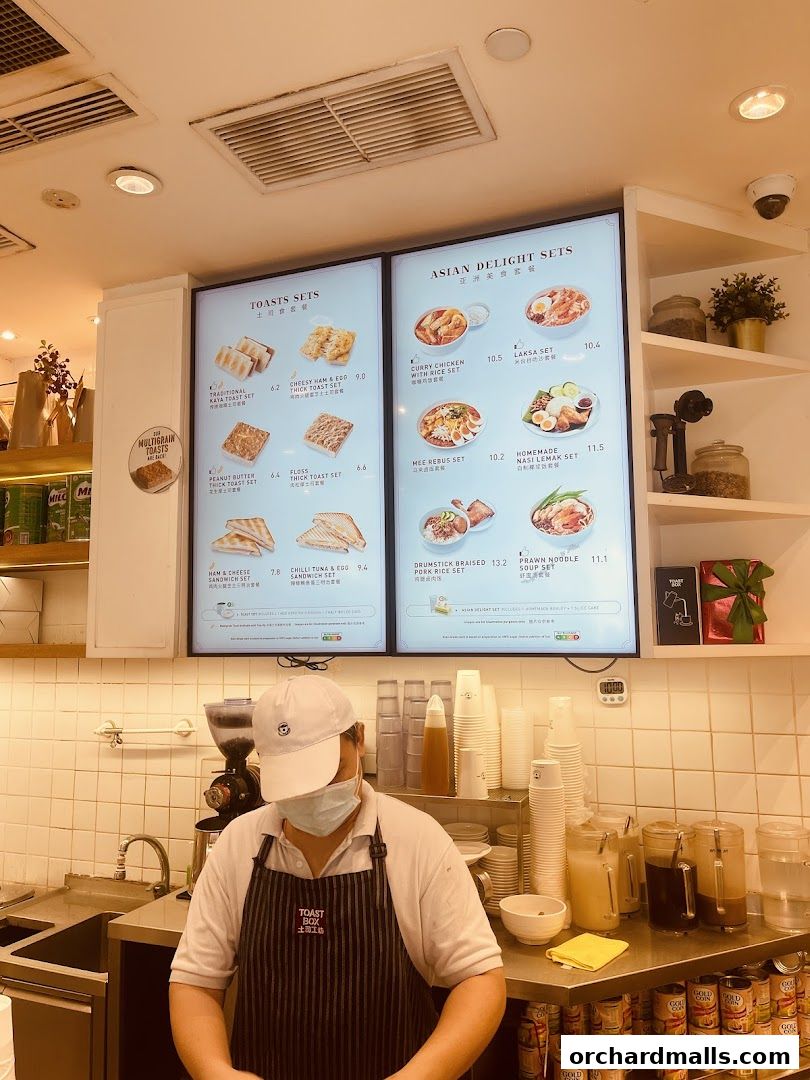 A menu board displaying various toast and Asian delight sets with prices.