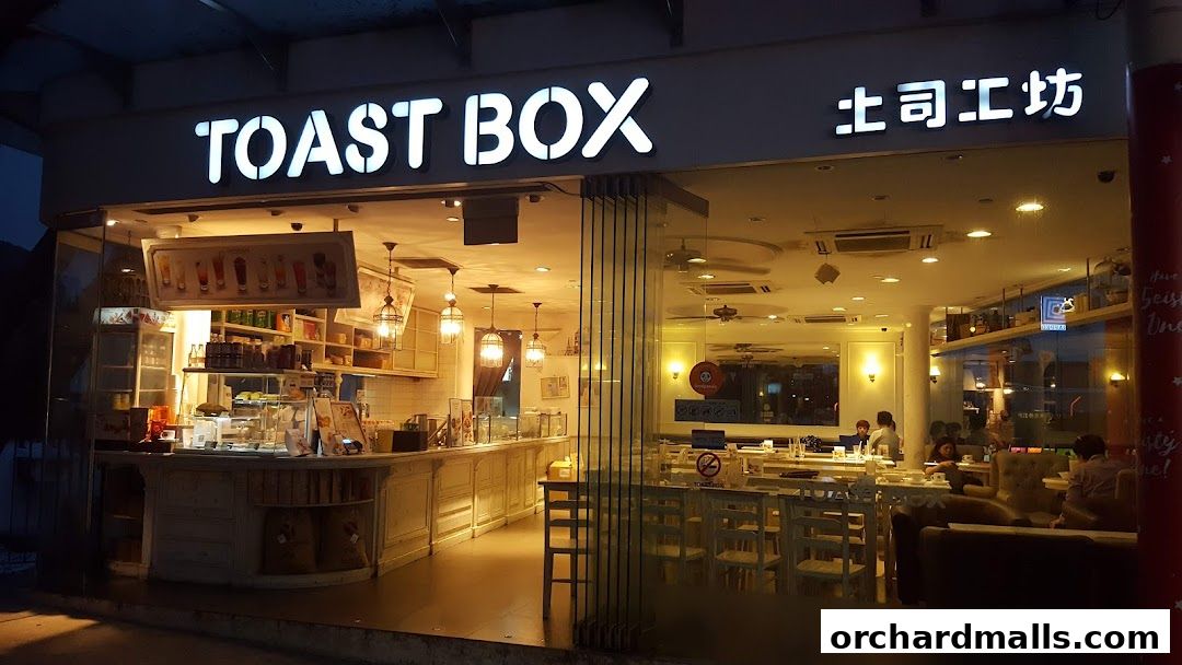 The exterior of Toast Box ION Orchard at night, showcasing its bright interior and seating area.