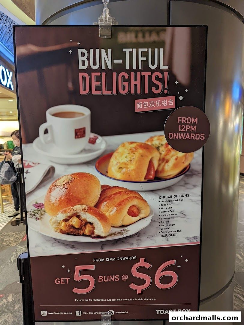 A promotional poster for Toast Box featuring a variety of buns and a cup of coffee.