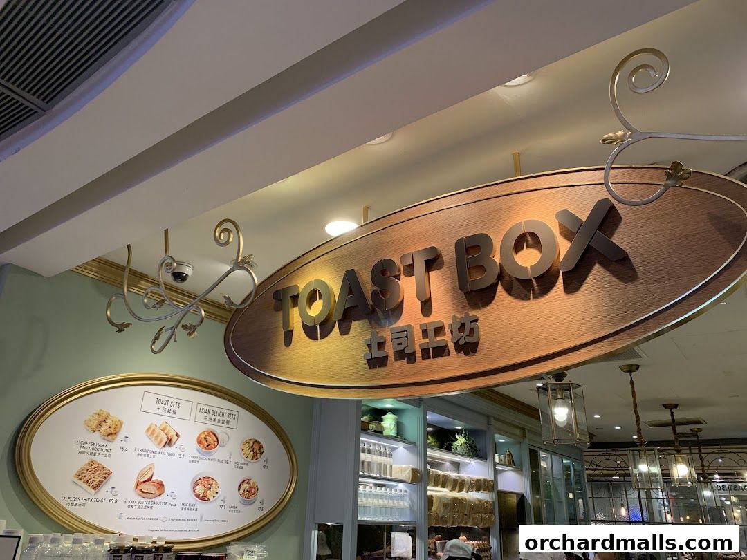 A sign for Toast Box with a menu board displaying various toast sets and Asian delights.