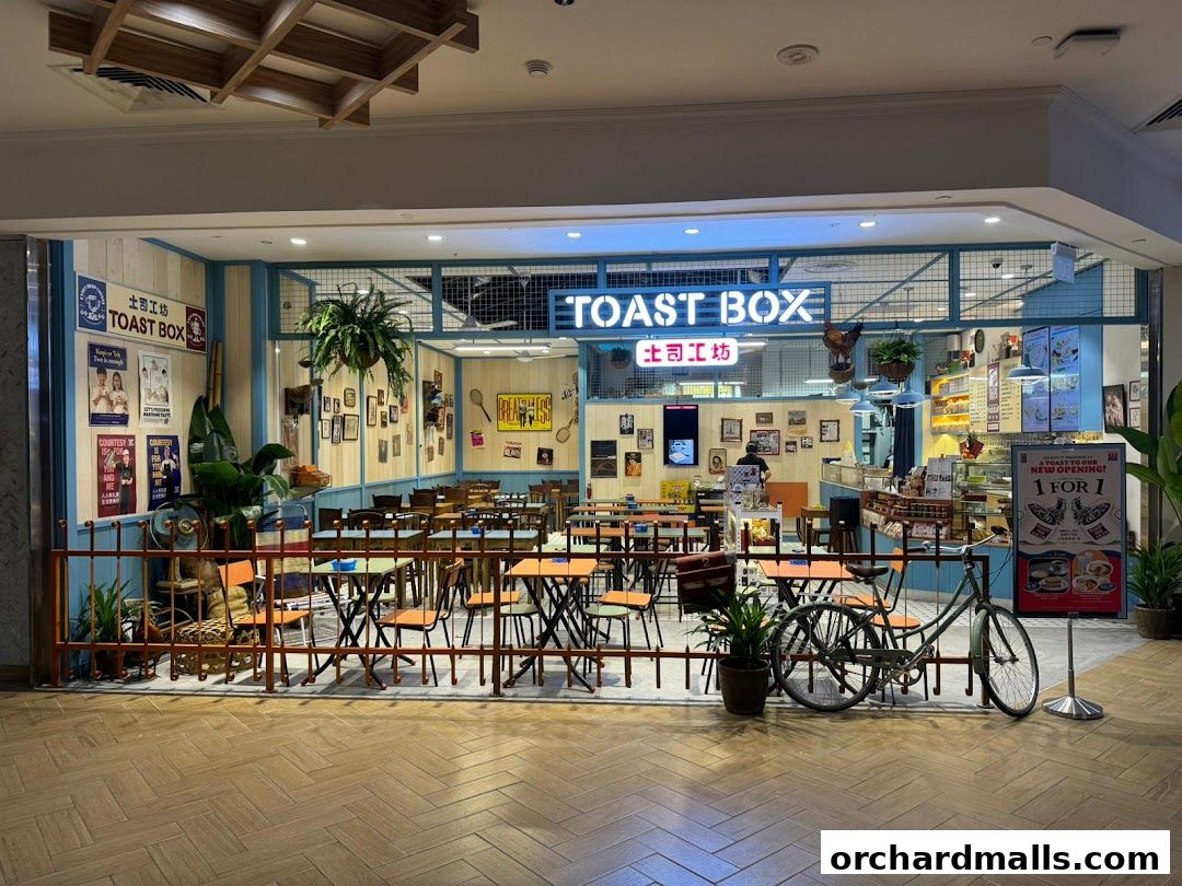 The exterior of Toast Box Takashimaya, featuring seating, a counter, and promotional signage.