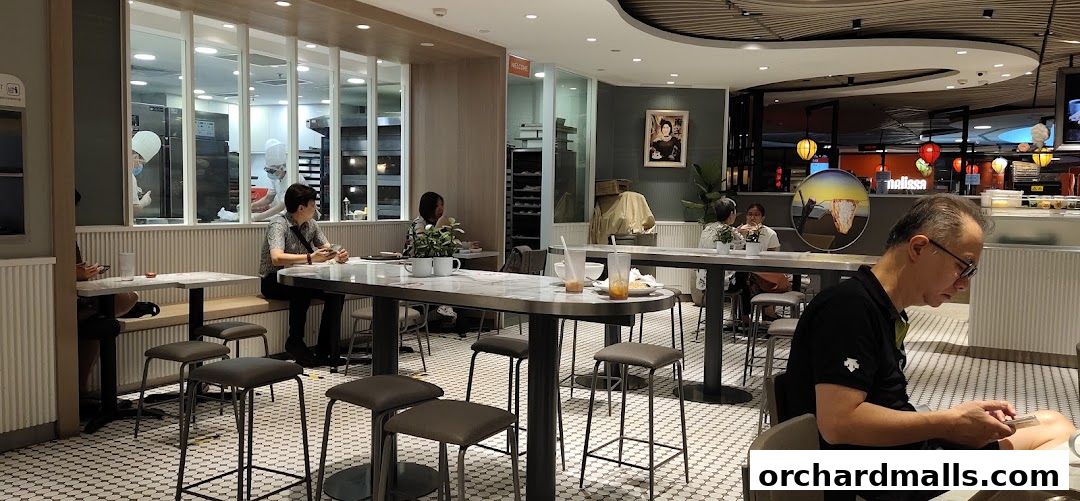 Interior of Toast Box Wheelock Place with diners and a visible kitchen.