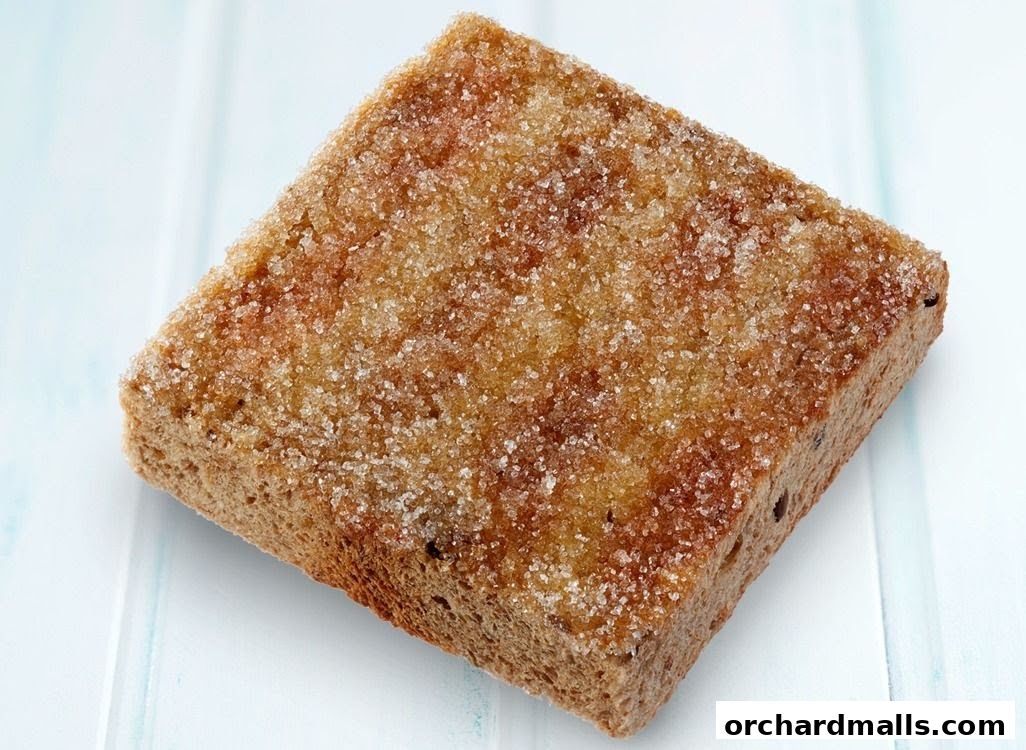 A close-up shot of a square piece of toast covered in sugar.