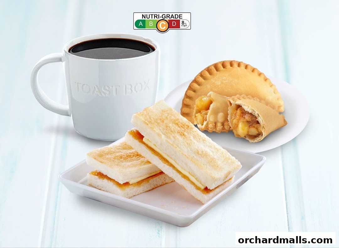 A mug of coffee, kaya toast, and a curry puff from Toast Box.