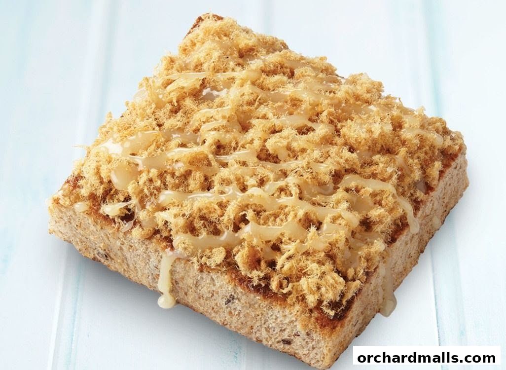 A slice of toast topped with shredded meat and drizzled with sauce.