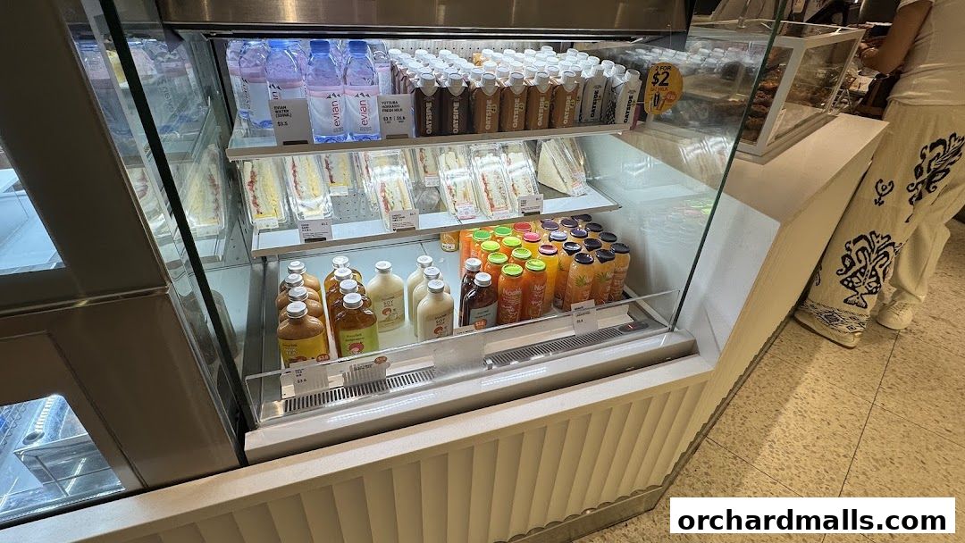 A display case filled with sandwiches, drinks, and bottled water at Toast Box.