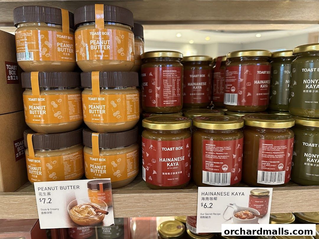 Jars of peanut butter and kaya spread are neatly stacked on shelves, with price tags visible.