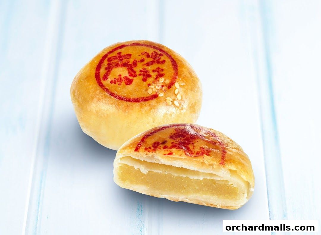 Two golden-brown pastries, one whole and one cut in half, revealing a yellow filling.