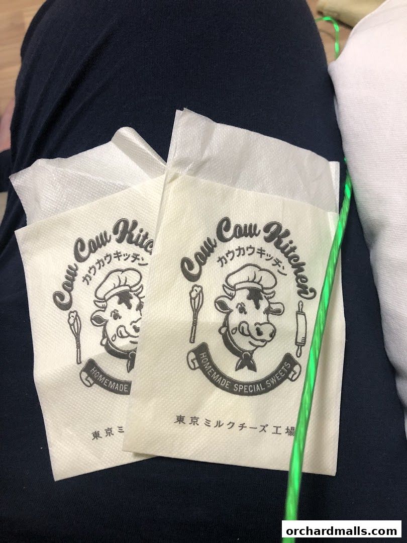 Two paper wrappers with a cow logo and Japanese text from Tokyo Milk Cheese Factory.