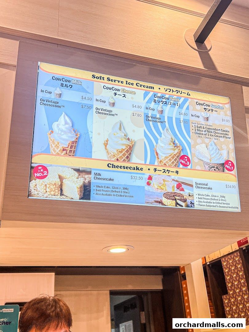 A menu board displaying soft serve ice cream and cheesecakes from Tokyo Milk Cheese Factory.