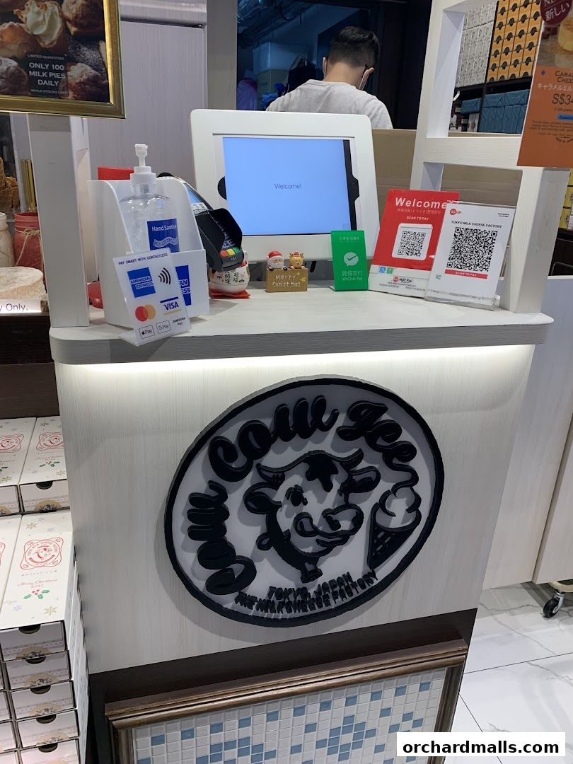 A counter at Tokyo Milk Cheese Factory with payment options and festive decorations.