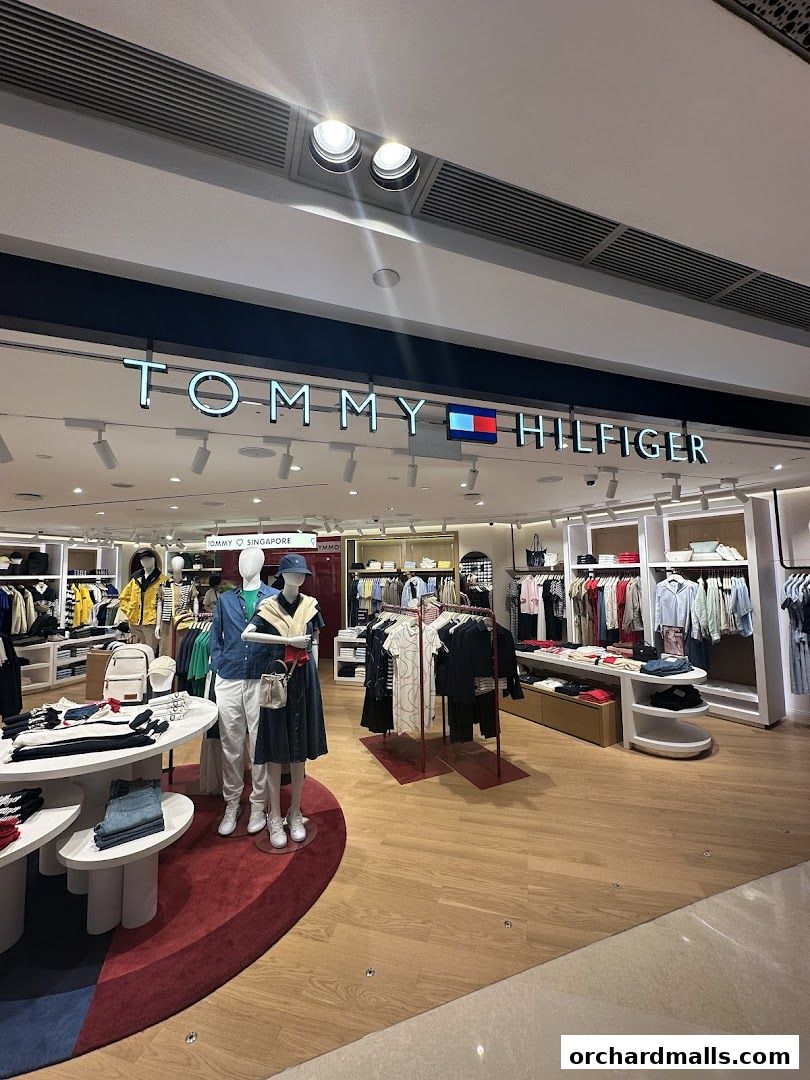 Interior view of a Tommy Hilfiger store showcasing clothing on mannequins and racks.
