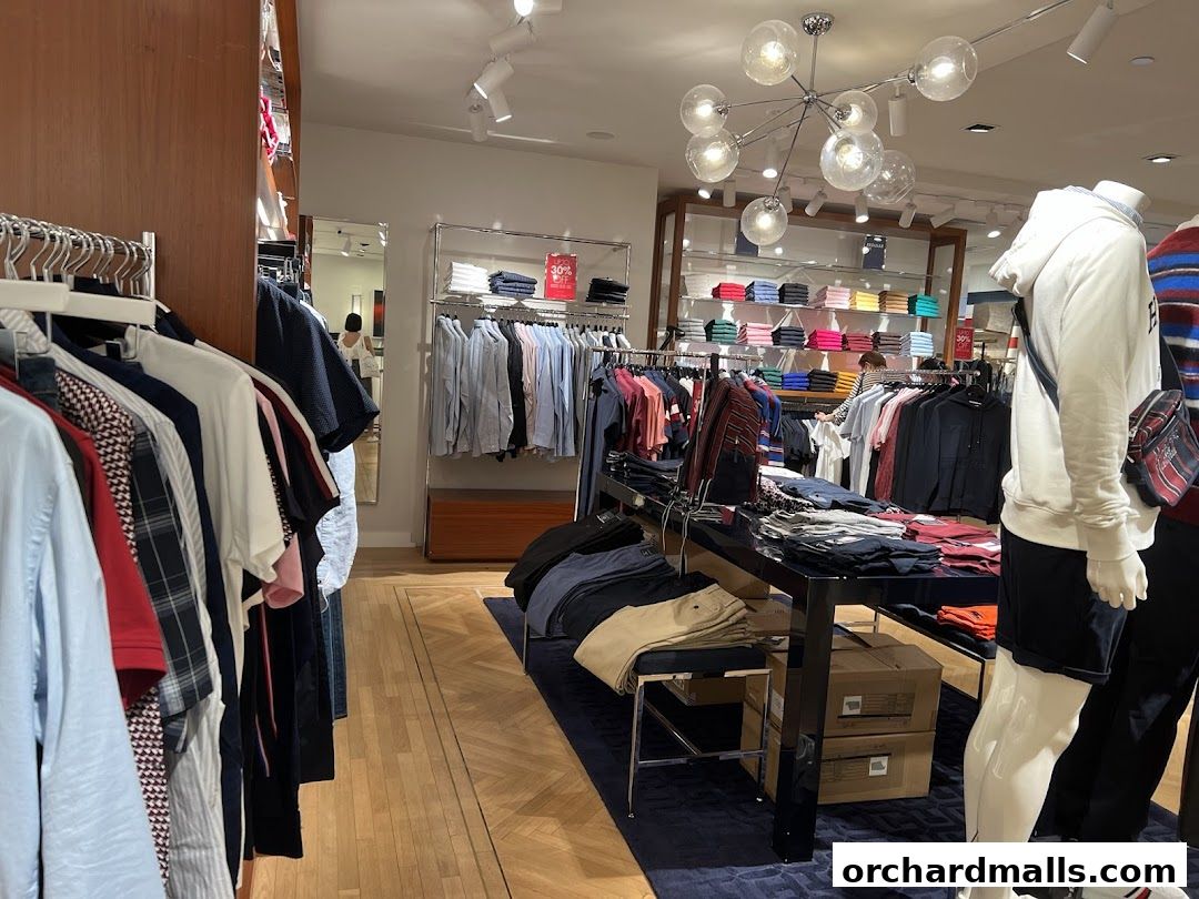 Interior view of a Tommy Hilfiger store with clothing racks and mannequins.