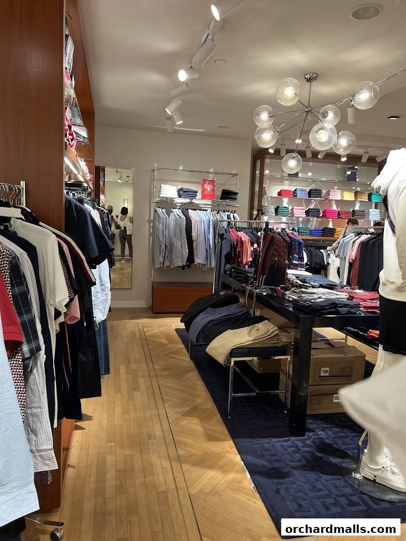 Interior view of a Tommy Hilfiger store showcasing neatly arranged clothing on racks and displays.