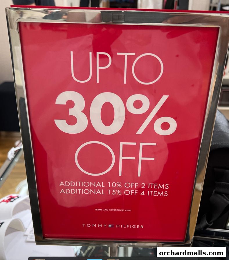 A sign advertising up to 30% off at Tommy Hilfiger, with additional discounts for purchasing multiple items.