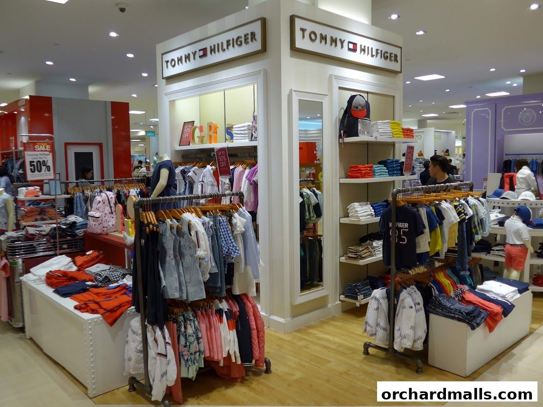 Interior view of a Tommy Hilfiger store showcasing clothing displays and sale signs.