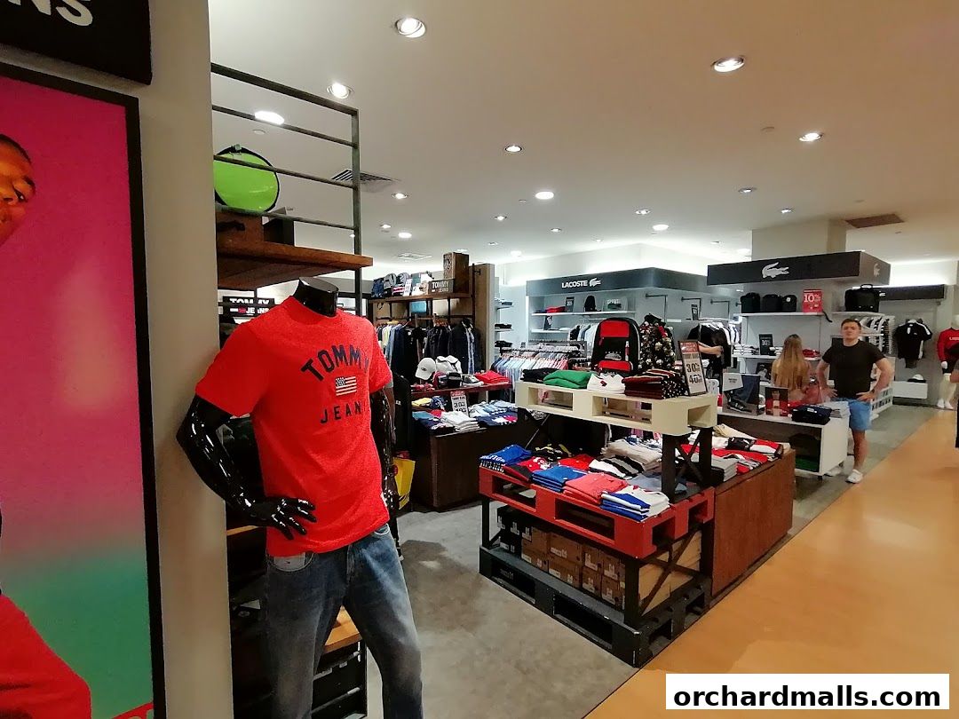 Interior view of a Tommy Hilfiger and Lacoste clothing store with mannequins and apparel displays.