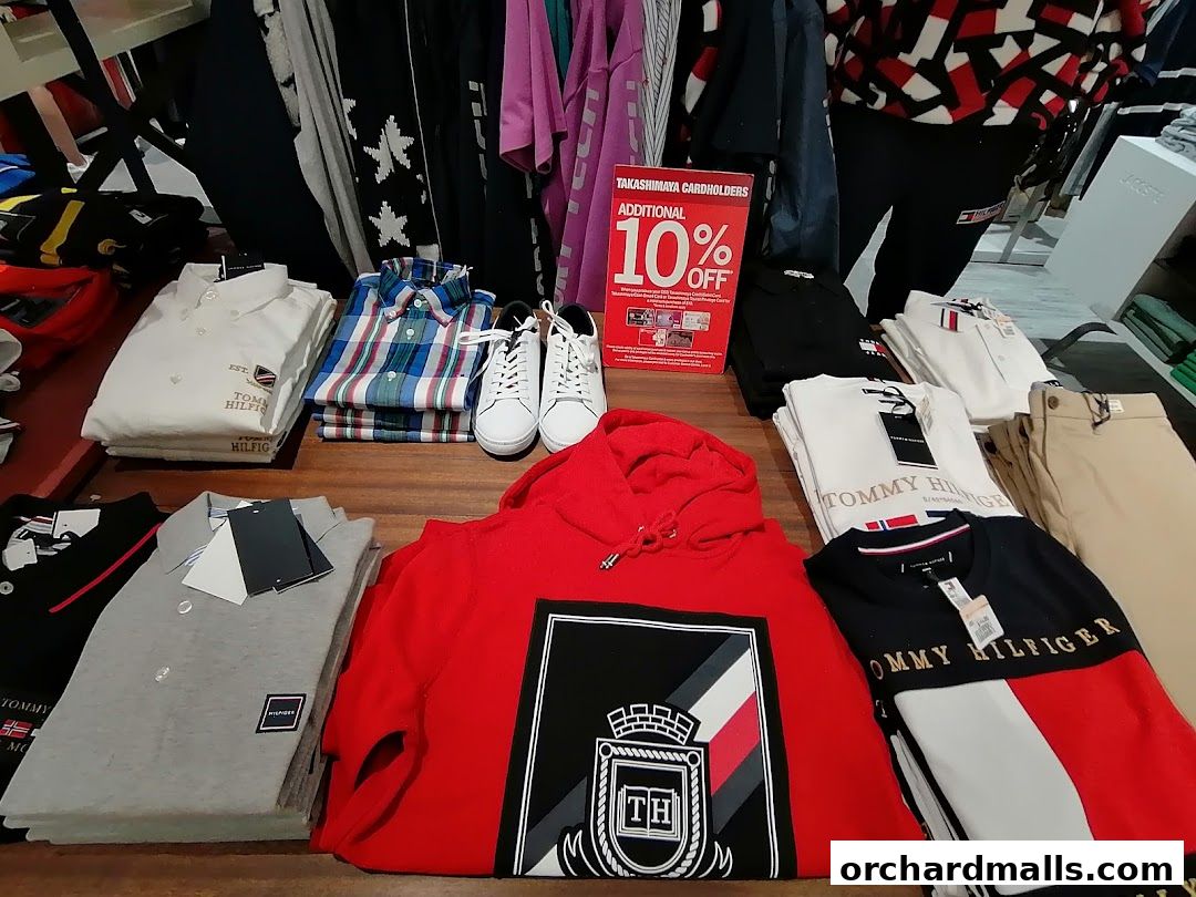 A display of Tommy Hilfiger clothing and shoes, including shirts, hoodies, and sneakers.