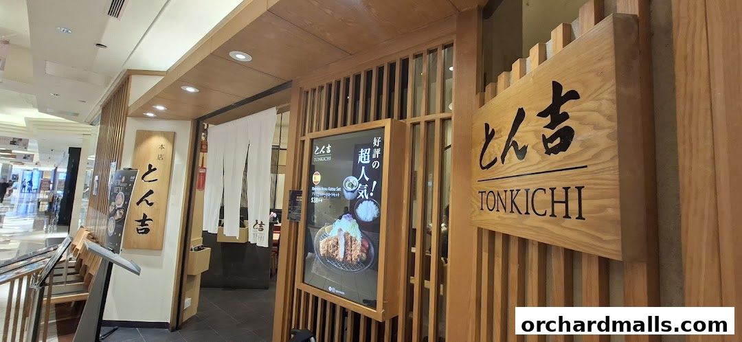 The entrance of Tonkichi, a Japanese restaurant, with wooden signage and a promotional poster.