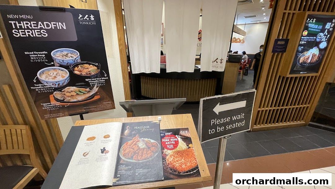 Tonkichi restaurant entrance with a new menu display and seating sign.