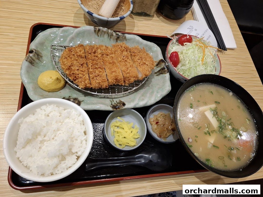 A delicious Tonkichi meal featuring crispy pork cutlet, rice, miso soup, and salad.