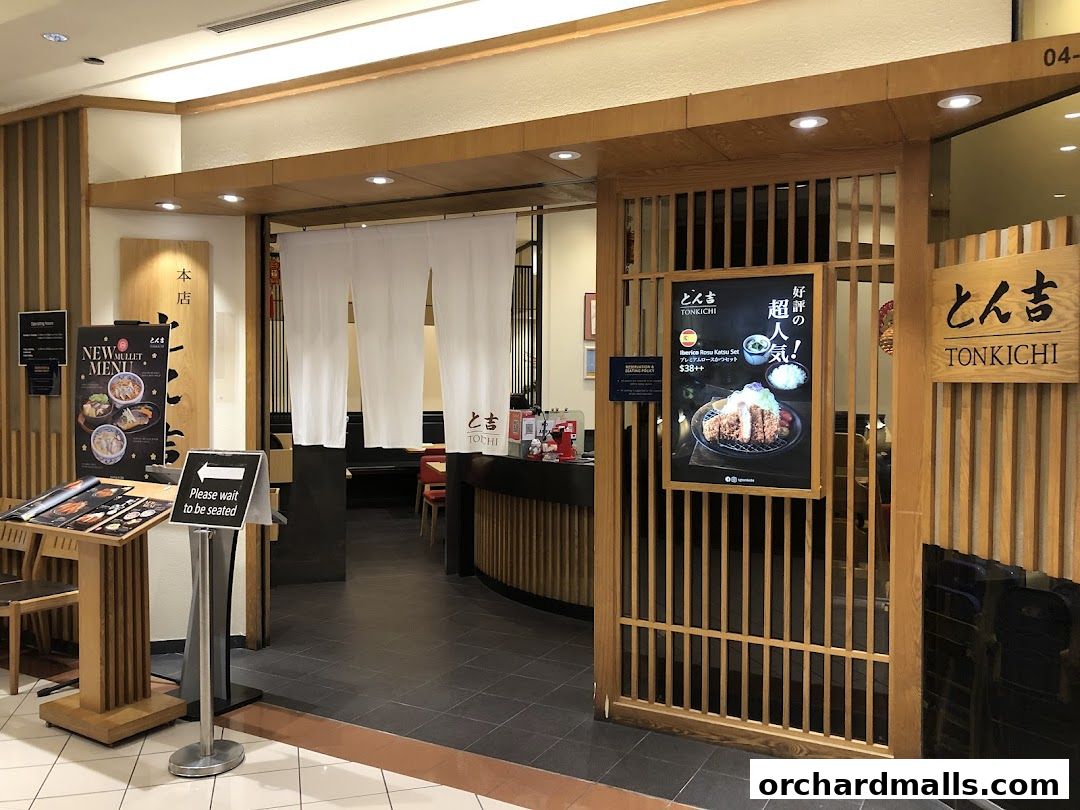 The entrance of Tonkichi, a Japanese restaurant, with a menu display and seating sign.