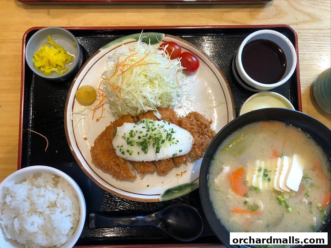 A delicious Tonkichi meal featuring crispy pork cutlet, rice, soup, and pickles.