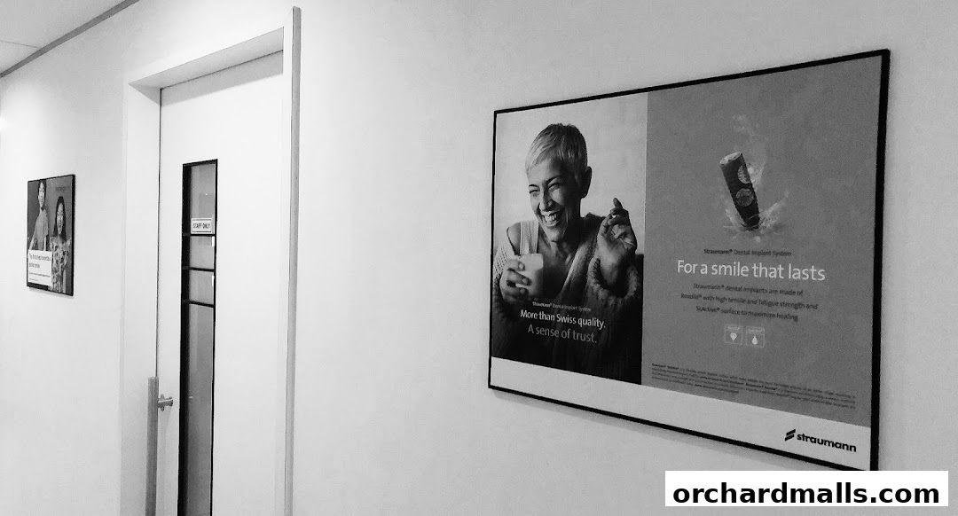 A hallway inside a dental clinic with posters on the wall and a door labeled 'Staff Only'.
