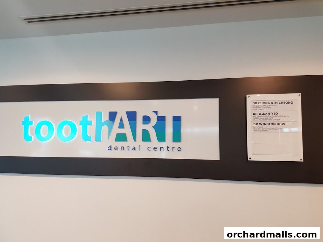 The Tooth Art Dental Centre logo and a list of dentists are displayed on a wall.