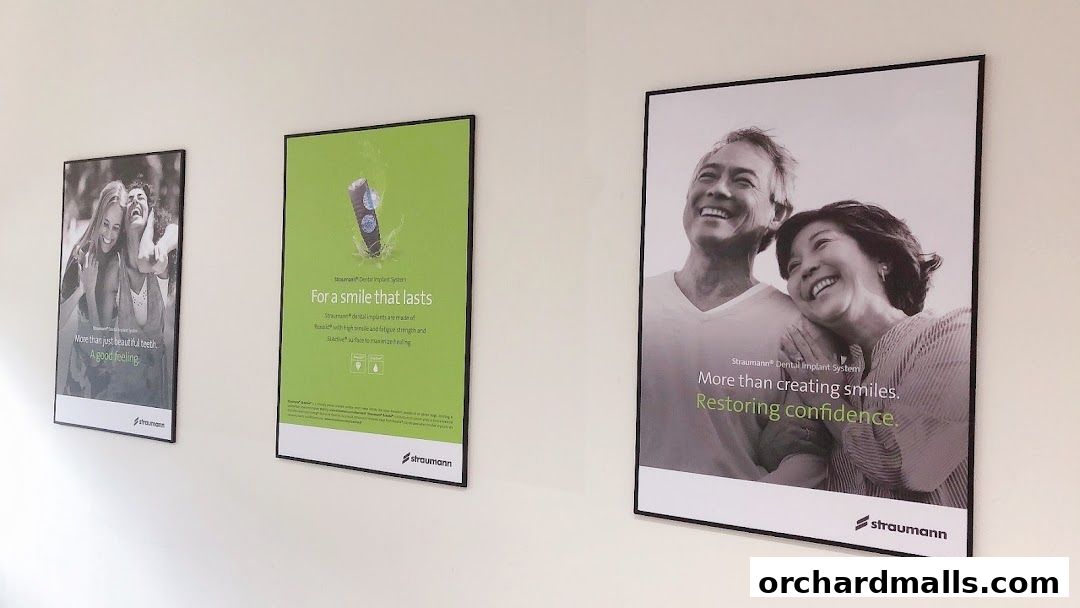 Three framed posters on a wall advertising dental implants and smiles.
