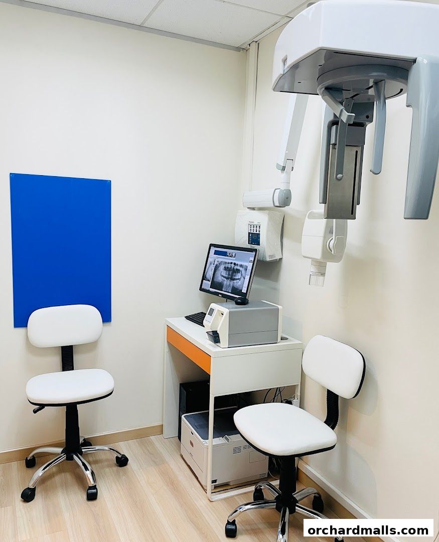 Interior of a dental clinic with X-ray equipment, computer, and chairs.