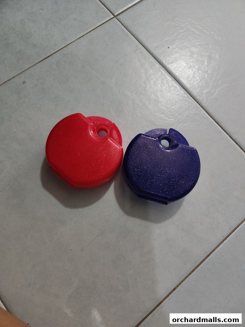 Two glittery, heart-shaped dental floss containers in red and blue.