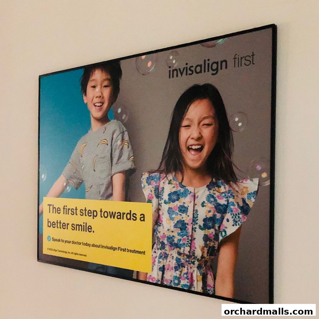 Advertisement for Invisalign First treatment featuring two happy children and the slogan 'The first step towards a better smile.'