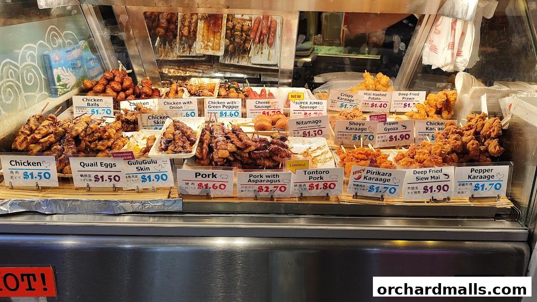 A display of various skewers and fried items with price labels.