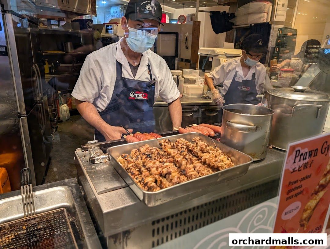 Chefs preparing yakitori skewers at a TORI-Q stall in ION Orchard.