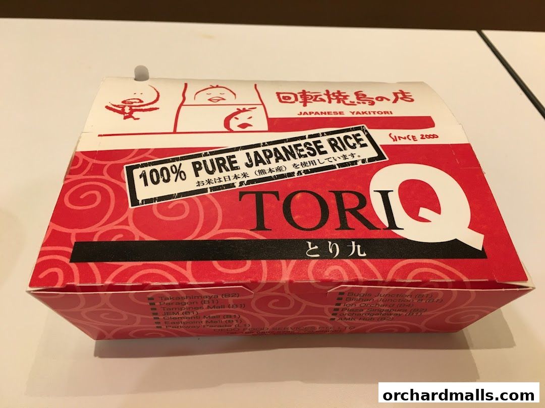 A red and white takeout box for TORI-Q Japanese Yakitori, featuring the brand logo and store locations.