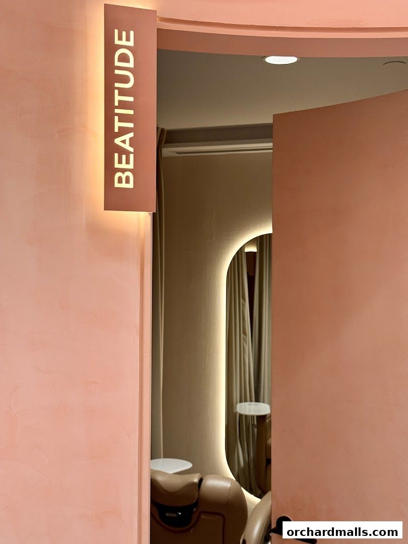 Interior view of a luxurious salon with a sign reading 'BEATITUDE' and a comfortable chair.